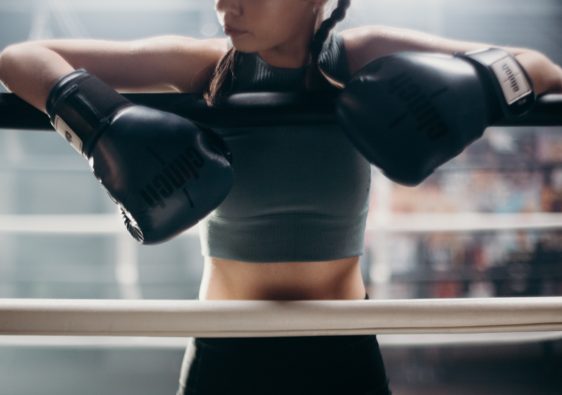 Female boxer with gloves on her hands ready to fight. Fighters don't quit.