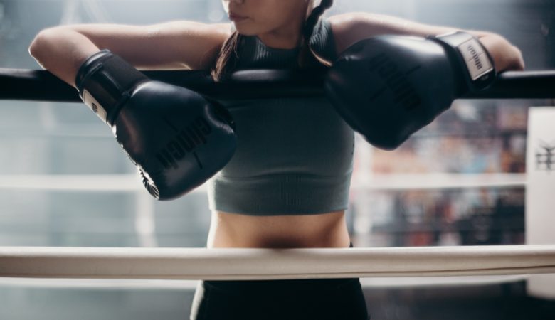 Female boxer with gloves on her hands ready to fight. Fighters don't quit.