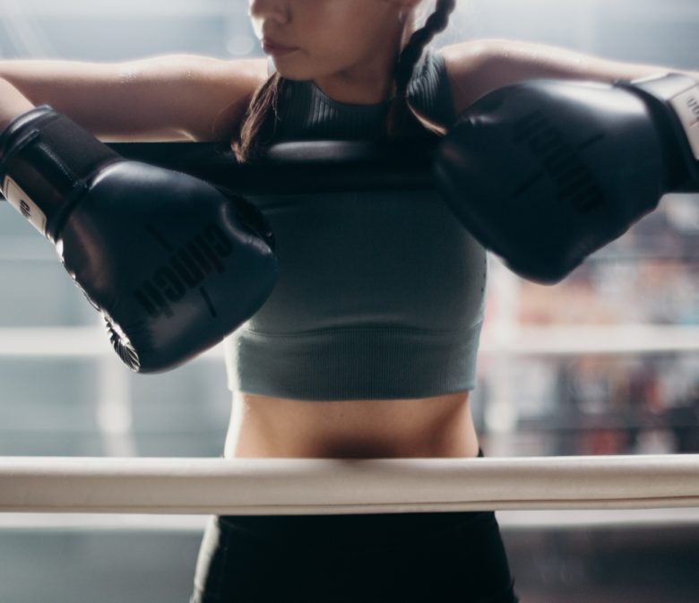 Female boxer with gloves on her hands ready to fight. Fighters don't quit.